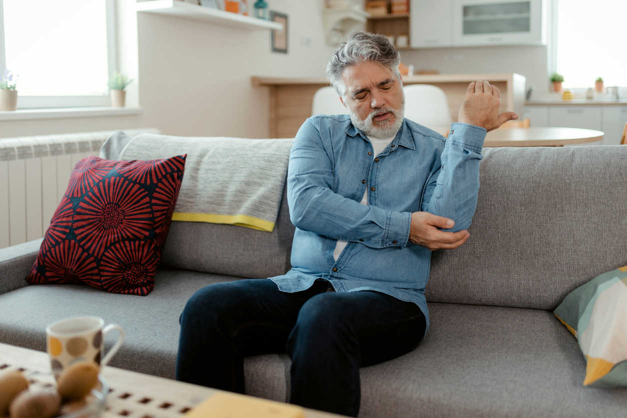 an-old-man-holding-his-elbow-in-pain