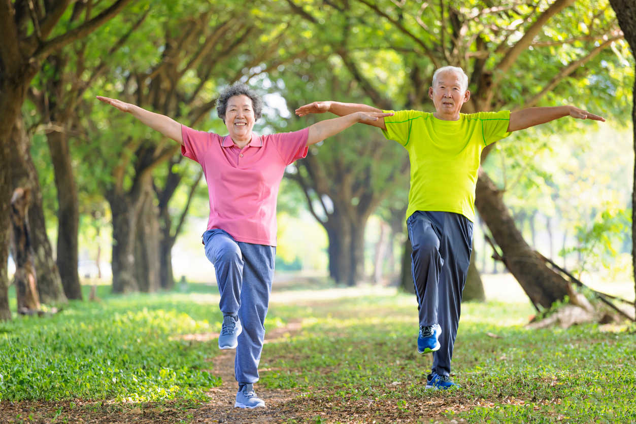 asian-man-and-woman-doing-balance-exercises-at-park