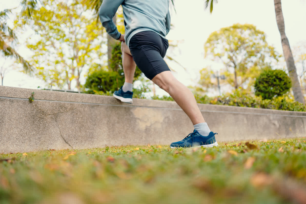 Close-up-of-mans-legs-stretching-hamstring-outdoors