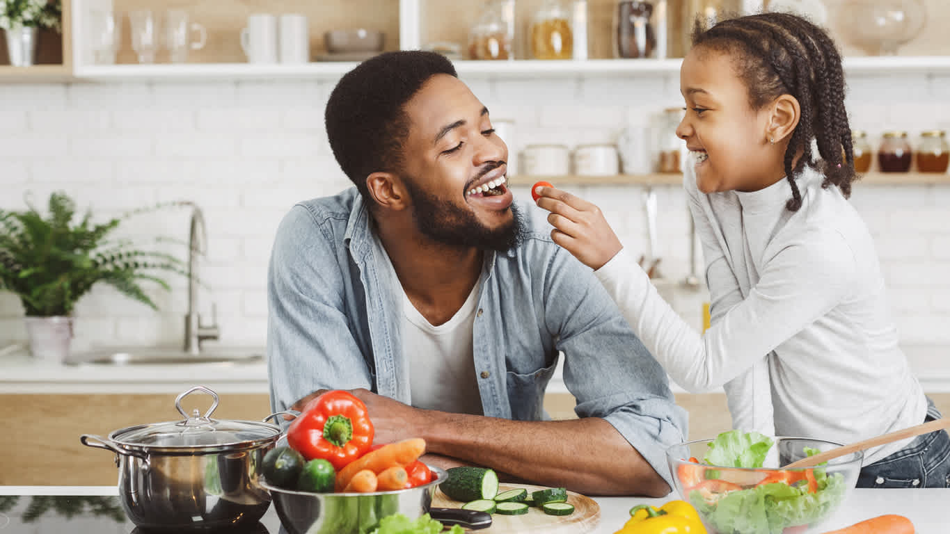 Dad-and-daughter-cooking-vegetables-on-kitchen