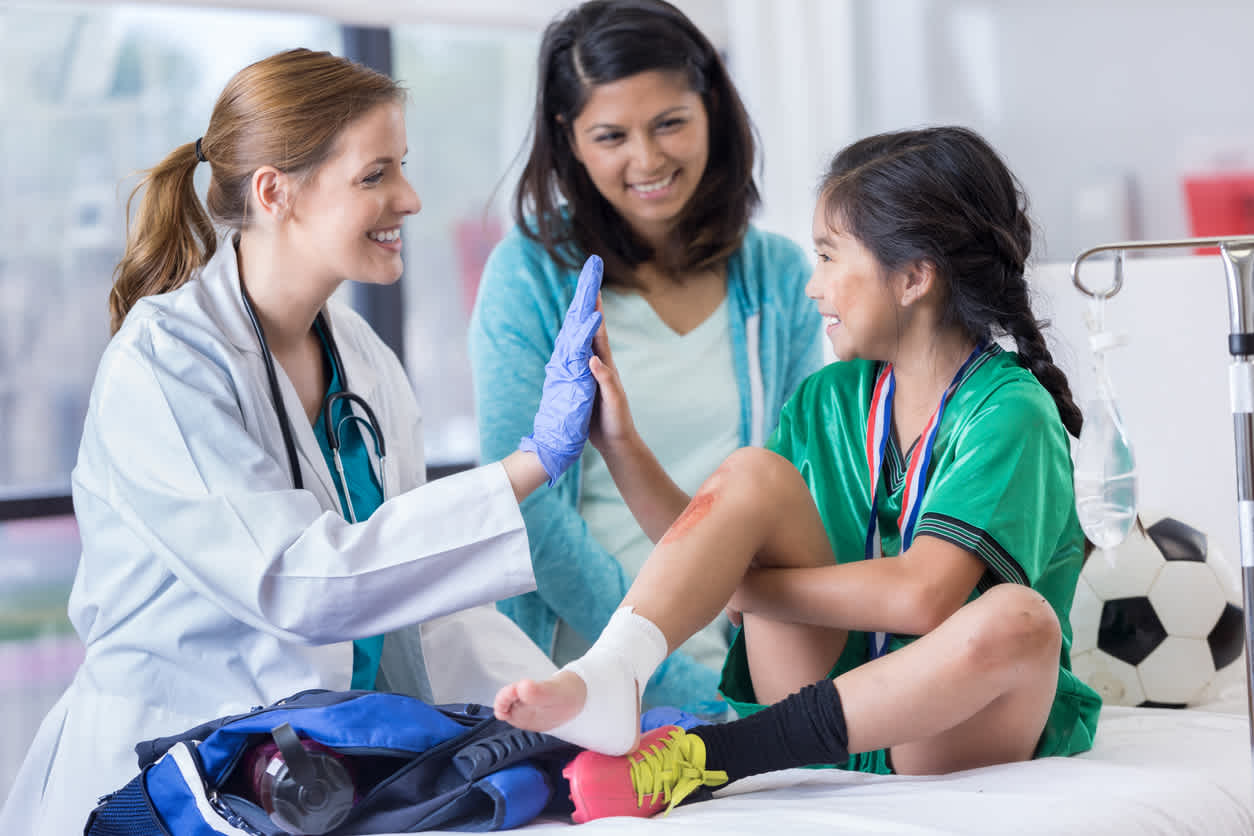 little-girl-with-scrapped-knee-sitting-at-doctors-office-being-treated