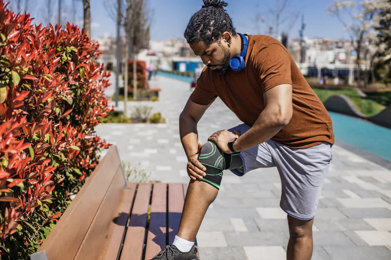 Man-outdoors-holding-his-knee-after-a-run