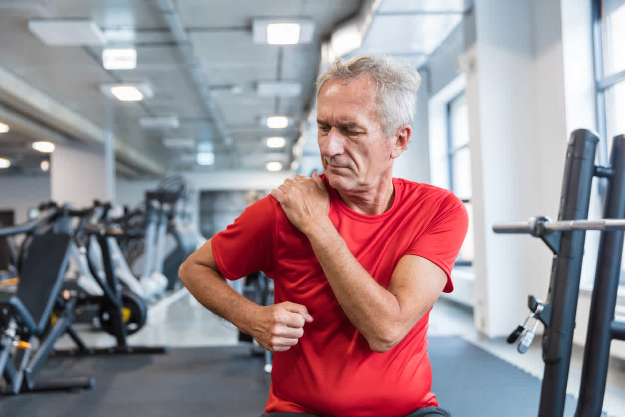 man-stretching-his-shoulder-in-gym