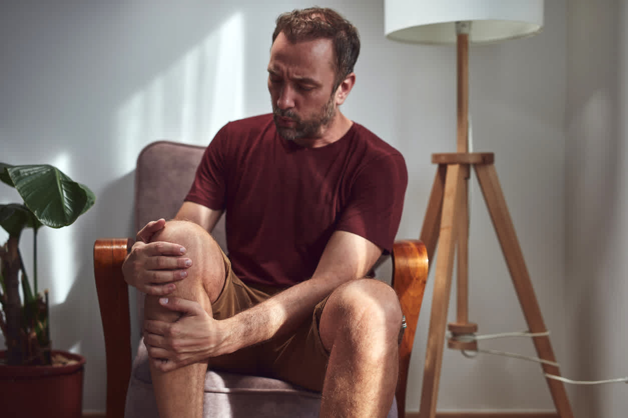 man feeling leg pain at night