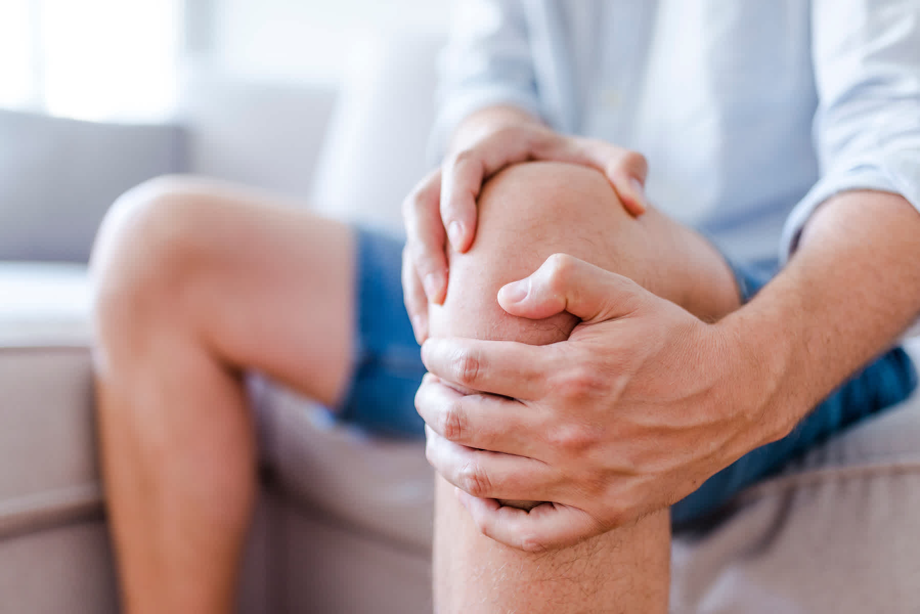 Man massaging his knee because of the pain