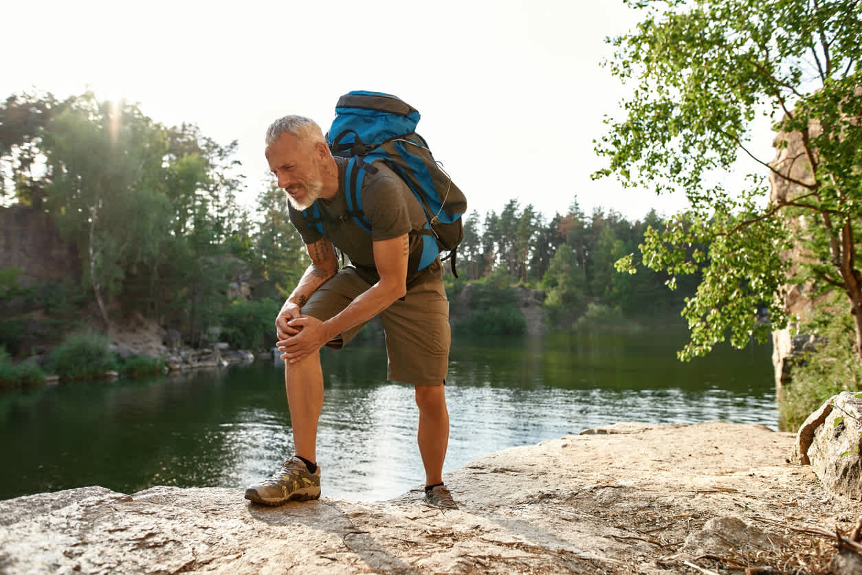 old-man-hiking-with-knee-pain