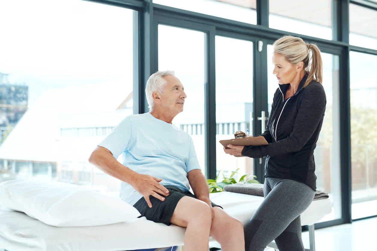 Older-man-at-doctors-office-being-checked-and-holding-his-hip