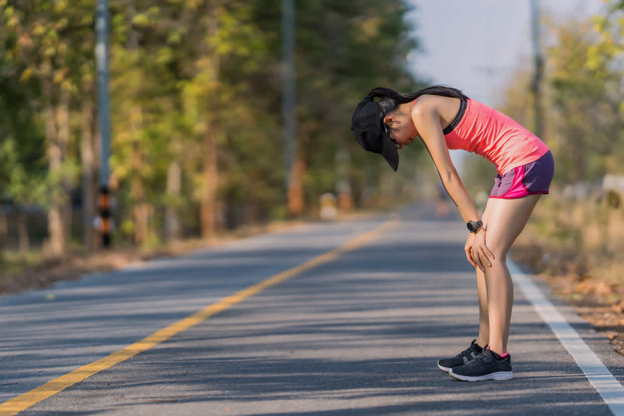 Tired-woman-after-outdoors-run-leaning-down