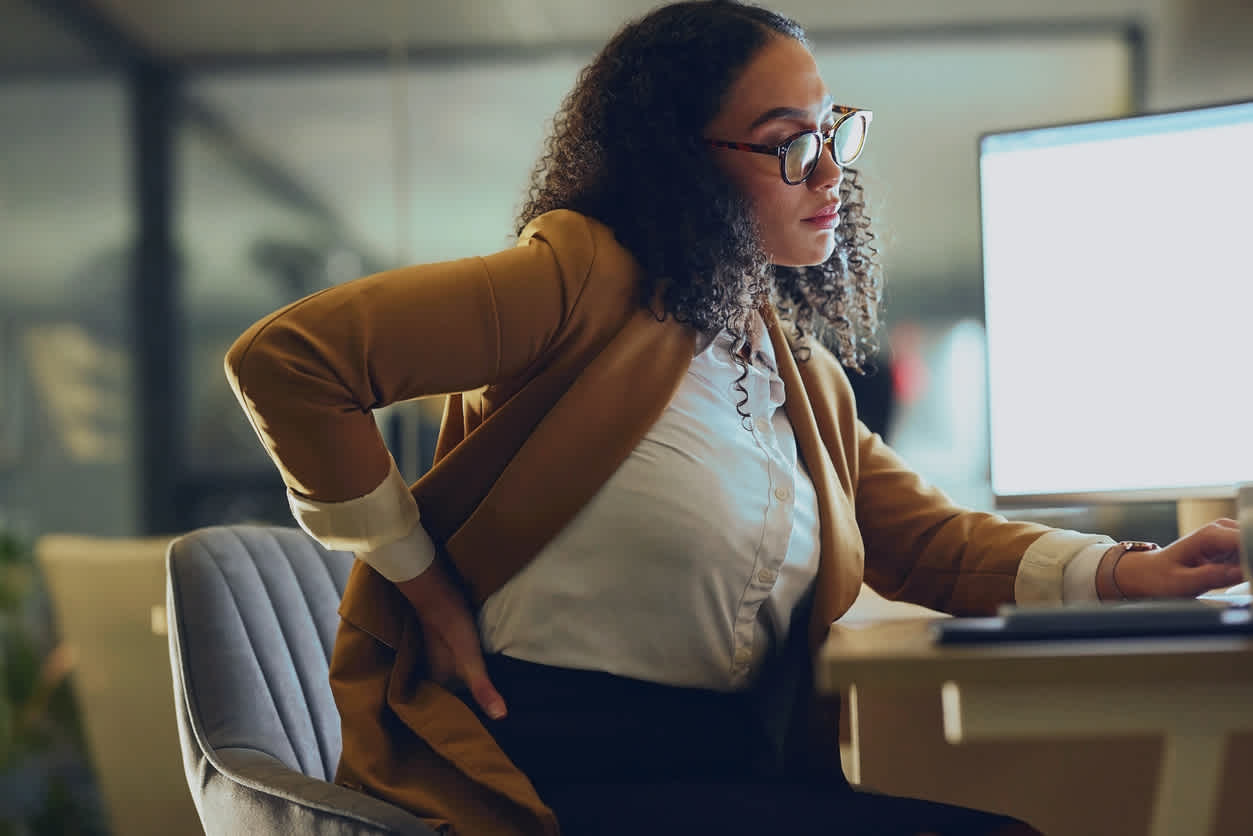 woman-at-work-using-computer-holding-lower-back-in-pain