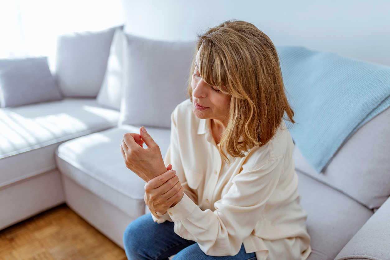 woman-holding-her-wrist-sitting-at-home