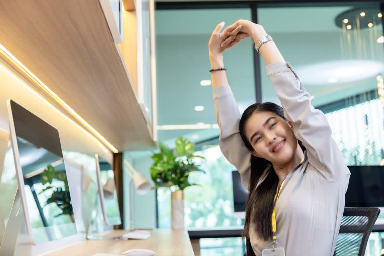 Woman-stretching-arms-above-shoulders-at-office
