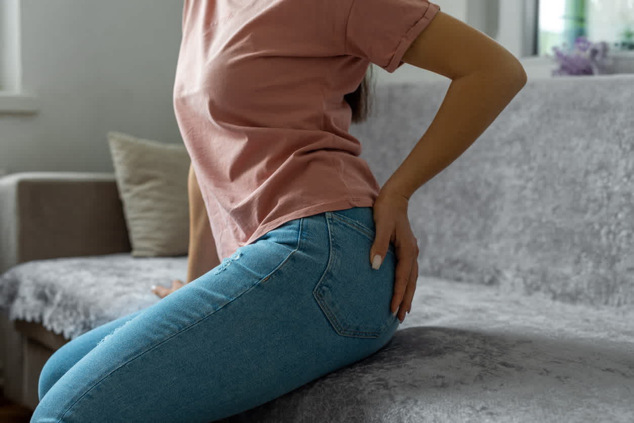 Woman with gluteus medius pain sitting on a couch
