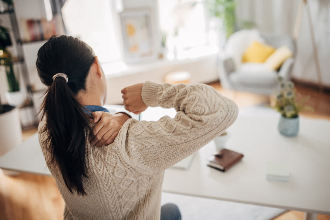 woman feeling knot in shoulder blade