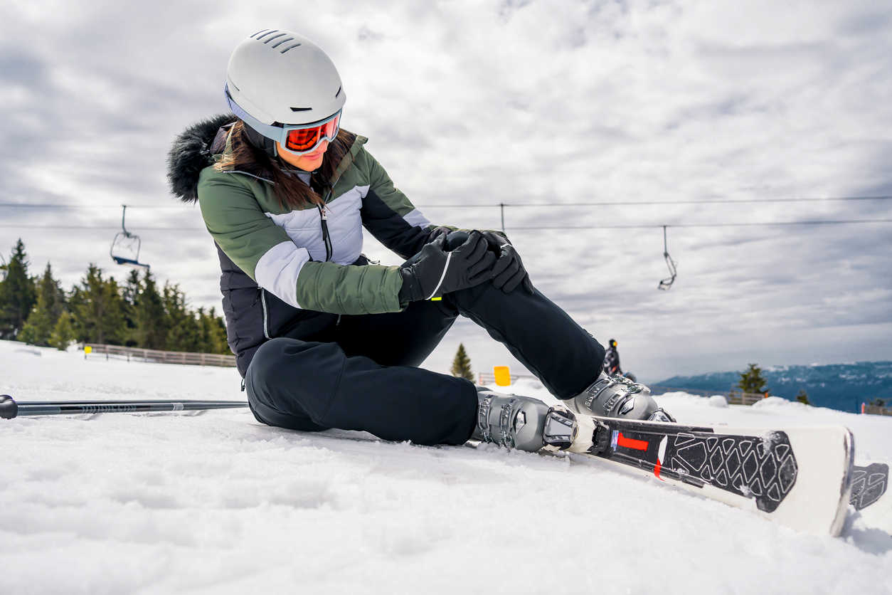 woman feeling knee pain after skiing