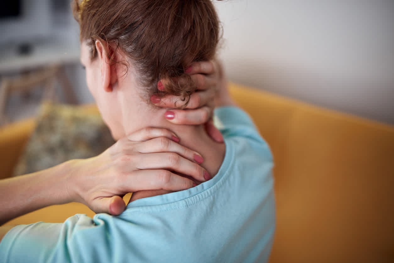 Woman robbing her neck with both hands