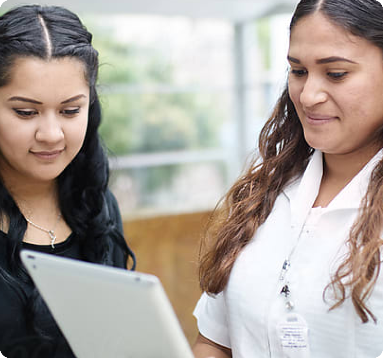 A physical therapist showing another woman her tablet